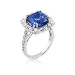 An evening cocktail tanzanite ring with a rich blue-violet tanzanite in a square cushion cut surrounded by a halo of diamonds