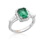 Emerald ring with tapered baguette diamonds and a diamond halo crafted in white gold