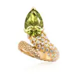 A pear cut vivid green diamond ring in the shape of a snake. Diamond snake ring is crafted in yellow gold with round-cut diamonds paved in snake skin scales.